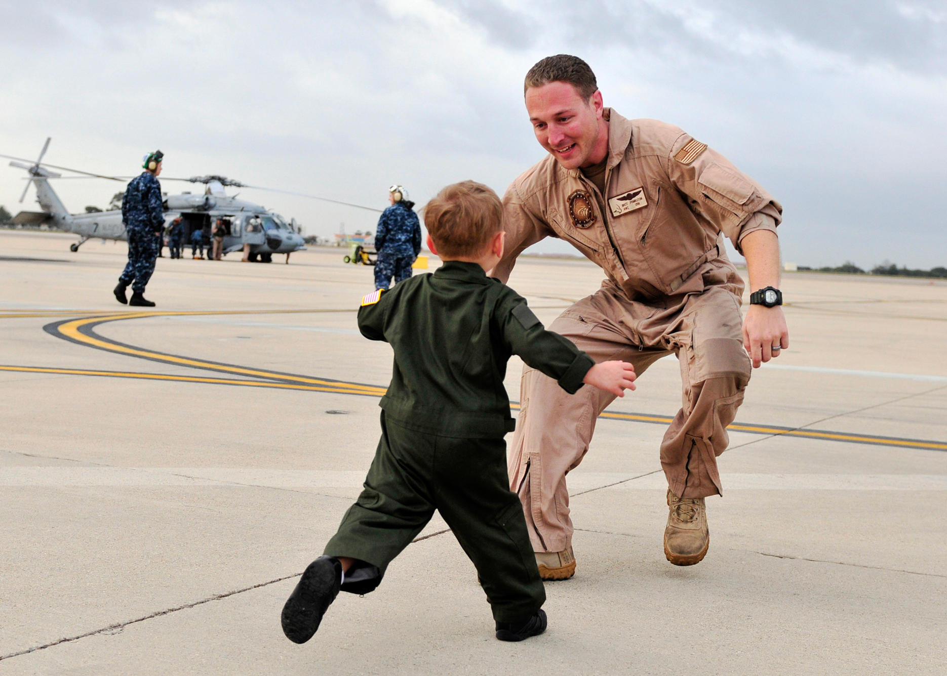 Child running toward veteran father on an airfield